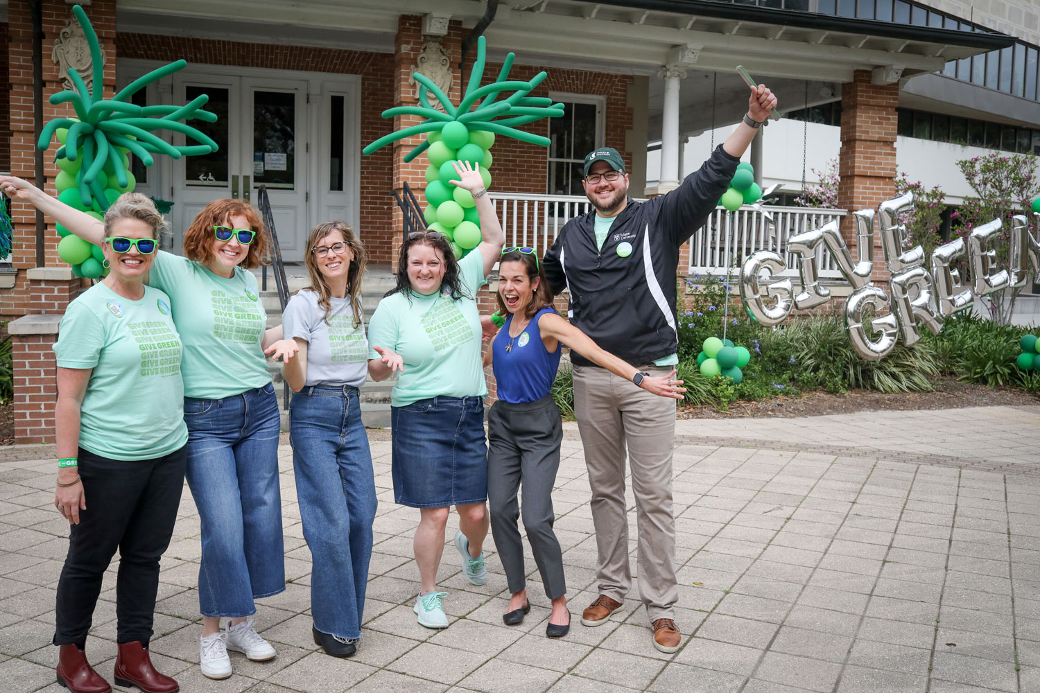 Staff cheering in front of Give Green ballons