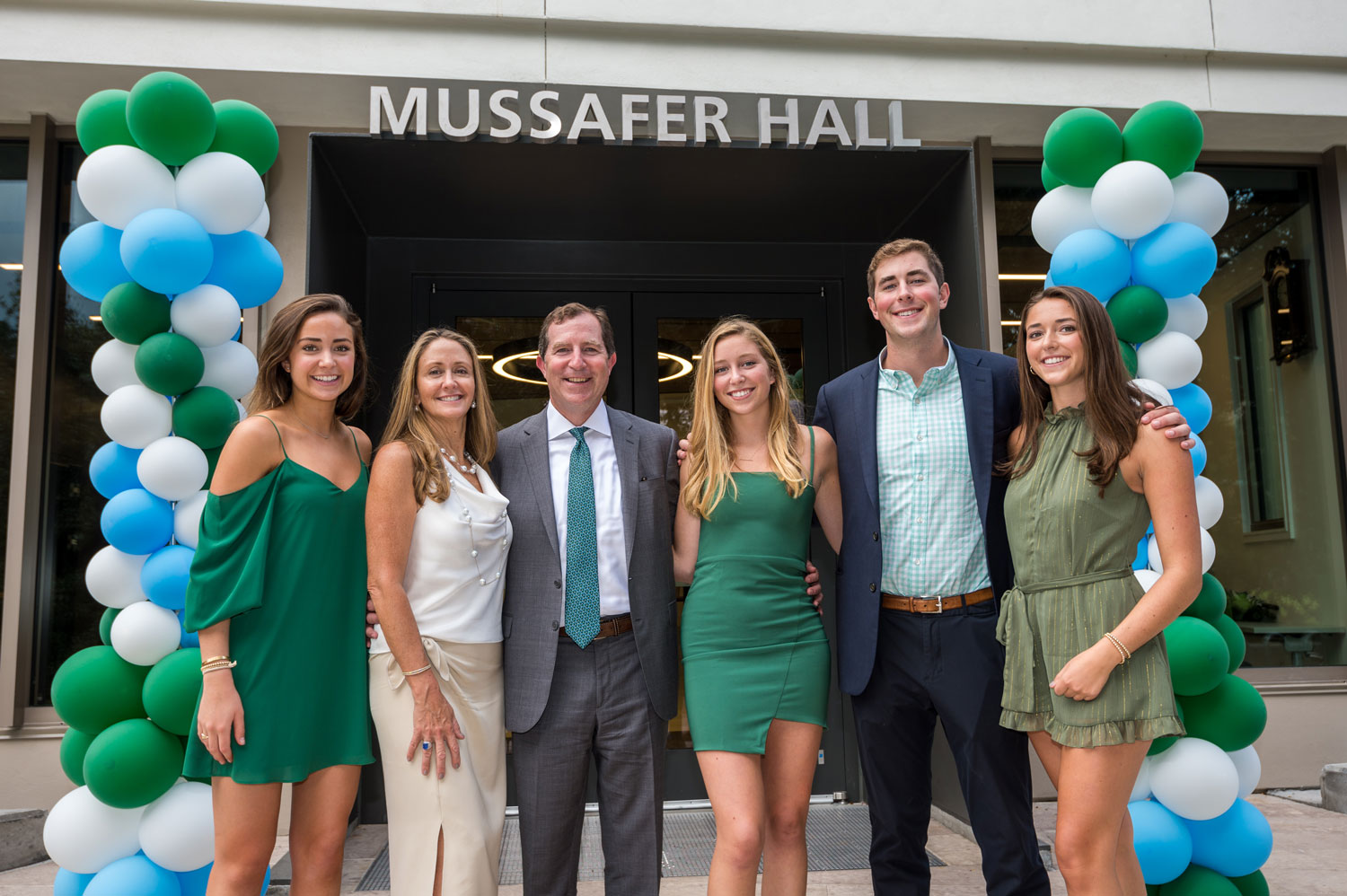 Mussafer family standing in front of Mussafer Hall and balloons
