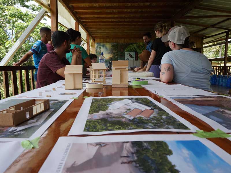 Tulane Architecture students outside with photos on a table